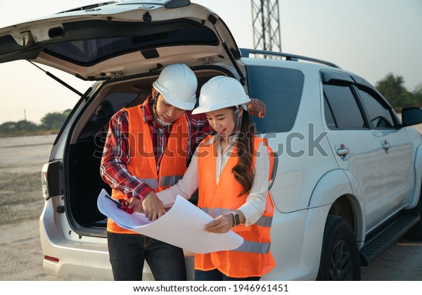 engineer worker holding blueprint with car and\
electric pole in morning blue\
sky