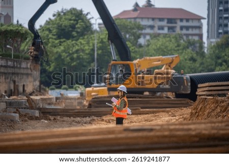 Engineer worker operations construction plans large black drainage pipe installing underground infrastructure heavy machinery importance of careful planning and teamwork in construction project.