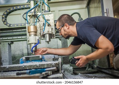 Engineer worker technician operating with CNC milling metal engraving machine in factory workshop.