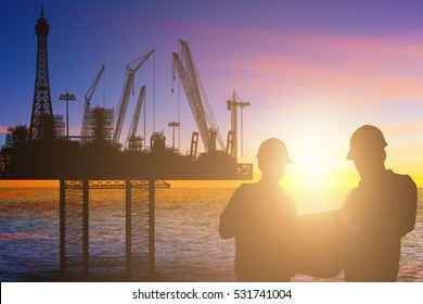 Engineer And Worker Working At A Off Shore Jack Up Rig In Middle Of Sea At Sunset Sky