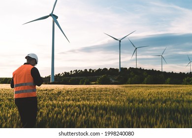 Engineer Working At Alternative Renewable Wind Energy Farm - Sustainable Energy Industry Concept