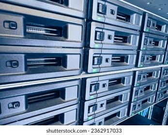 Engineer working in a data center. Hard drive insert. many hard drives and LED lamps blinks SSD with Blinking Lights in Modern Data Center. Advanced Cloud Computing and Machine Learning Concept.