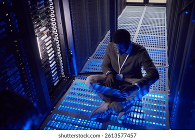 Engineer working in a high-tech server room, managing data servers and ensuring smooth operation of systems. Blue lighting adding to the futuristic atmosphere