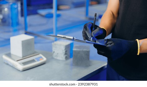 Engineer working in industry lab for testing building materials. Controls size and quality of concrete cube in laboratory. - Powered by Shutterstock