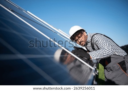 Engineer working on checking and installing solar panels in a solar power station, promoting renewable energy and eco friendly practices