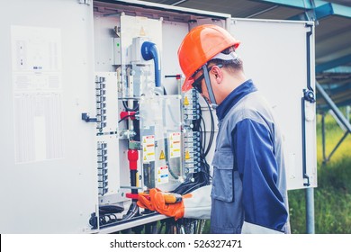 engineer working on checking and maintenance equipment at green energy solar power plant: cheking status inverter