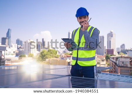 Engineer working on checking solar panels on buiding rooftop with tablet