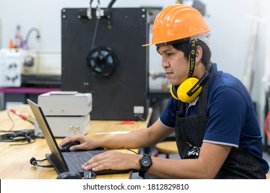Engineer Working on Computer and 3D printer behind		