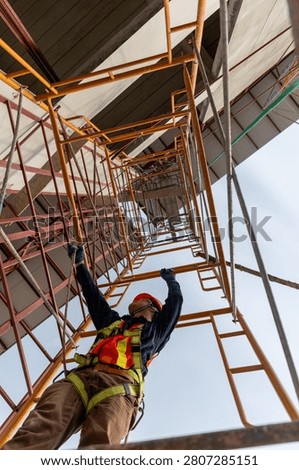 Engineer working on construction site climbing scaffolding to ensure safety and progress in building development