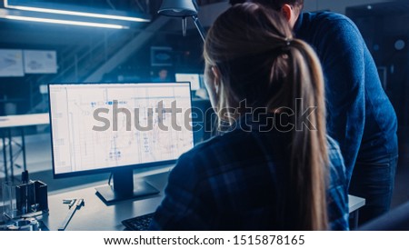 Engineer Working on Desktop Computer, Screen Showing CAD Software with Technical Blueprints, Her Male Project Manager Explains Job Specifics. Industrial Design Engineering Facility Office