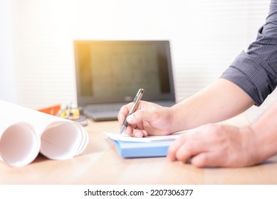 An engineer is working on a drawing on his desk. - Shutterstock ID 2207306377
