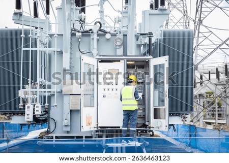 An engineer is working on high voltage power substation performing inspection and check to ensure infrastructure operates safely and efficiently in this industrial environment
