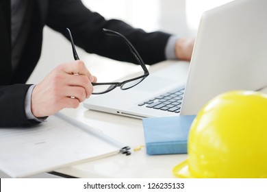 Engineer Working On Laptop With Helmet On Table