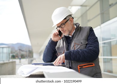 Engineer working on outdoor project and talking on phone 