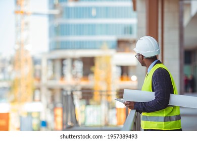 Engineer Working On Outdoor Project. Portrait Of An Handsome Black Engineer. Male Work Building Construction Engineering Occupation Project. Engineer With Hardhat Using Tablet Pc Computer Inspecting