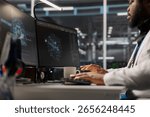 Engineer working on PC in data center housing artificial intelligence infrastructure. IT expert using computer in server hub workspace filled with AI machine learning supercomputers