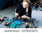 Engineer working on racing fpv drone combat kamikaze bomber in workshop.