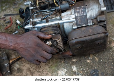 An Engineer Working On A Small Electricity Generator In An Engineering Workshop, Undergoing Repair And Maintenance For Better Generation Of Electrical Energy For Household And Business In Nigeria