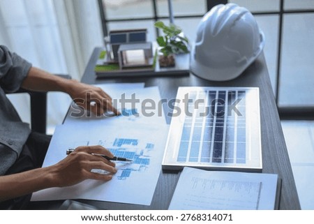 Engineer Working on Solar Panel Design and System Planning on Desk.