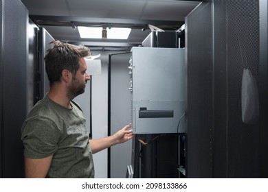 IT engineer working In the server room or data center The technician puts in a rack a new server of corporate business mainframe supercomputer or cryptocurrency mining farm. 