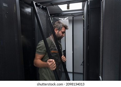 IT engineer working In the server room or data center The technician puts in a rack a new server of corporate business mainframe supercomputer or cryptocurrency mining farm. 