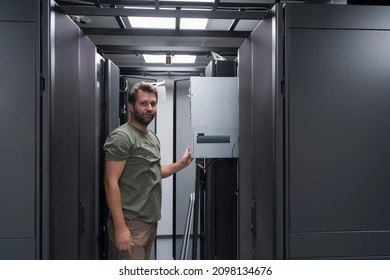 IT engineer working In the server room or data center The technician puts in a rack a new server of corporate business mainframe supercomputer or cryptocurrency mining farm. 