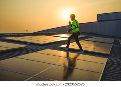 Engineer working at solar cell farm power plant with sunset in evening - Shutterstock ID 2320552595