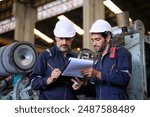 Engineer is working at train machine part factory. Blue collar worker and heavy industry.