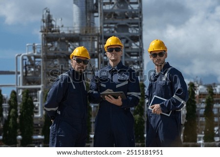 Engineer working using tablet together at station refining oil petrochemical. Technician worker check quality oil industry factory. Inspector standing at zone gas with refinery building background.