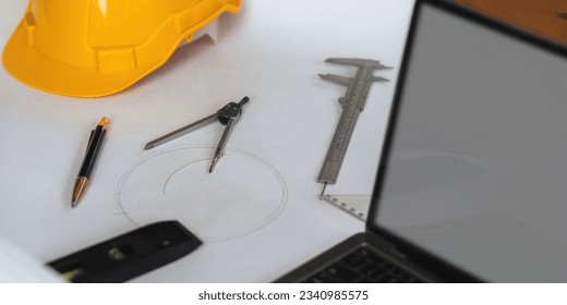 Engineer workplace with blueprints, compass, pen, construction level and safety helmet - Powered by Shutterstock