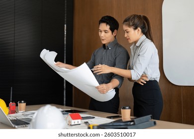 Engineering Collaboration and Project Planning. Two professionals passionately discussing architectural blueprints.