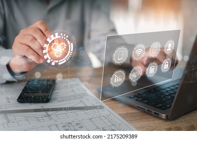 Engineering concept and technology on virtual screen, Businessman use pencil pointer in icon with business engineer planning and construct work document and laptop on wood table in office