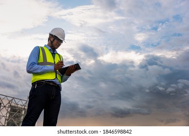 Engineering Consulting People on construction site holding tablet in his hand. Building inspector. Construction site checking by technology and business workflow of new building. v