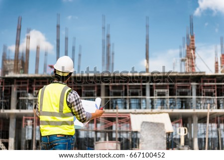 Engineering Consulting People on construction site holding blueprint in his hand. Building  inspector. Construction site check drawing and business workflow of new building