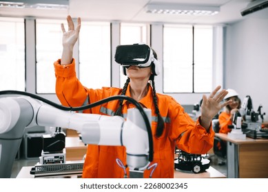 Engineering female wearing VR glasses for simulate control automation robotic welding machines in modern factory lab. Concept of innovation artificial intelligence for industrial revolution.