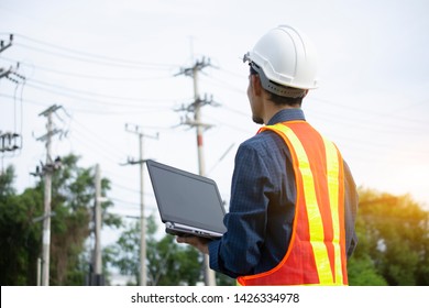 Engineering Holding Notebook inspects the wires on the electrical pole.