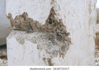 Engineering inspection of structures using destructive methods. Damaged concrete construction with exposed steel reinforced rods.