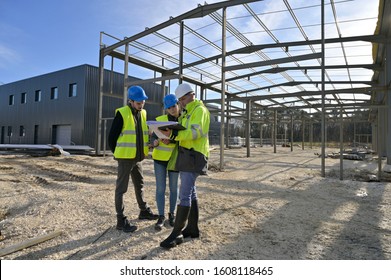 Engineering Instructor Working On Building Site With Apprentice