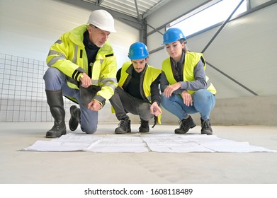 Engineering Instructor Working On Building Site With Apprentice