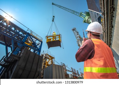 engineering, loading master connecting to gantry crane driver by walkie talkie for lifting safety in loading the goods or shipment, lifting by gantry crane, working at risk on the high level insurance - Powered by Shutterstock