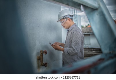 Engineering Man Construction And Checking Development Of A Small Business Hall. Reliable Civil Engineer Working On A Construction Site, Foreman At Work