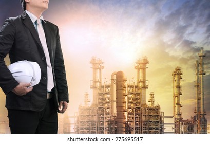 engineering man with safety helmet standing against oil refinery plant in heavy petrochemical industry estate use for fossil energy and petroleum power topic