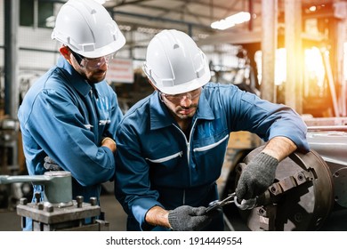 Engineering man wearing uniform safety workers perform maintenance in factory working machine lathe metal, Heavy industry worker man concept.