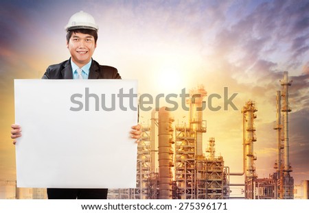 engineering man with white empty white broad standing in front of oil refinery industry estate use for industrial theme