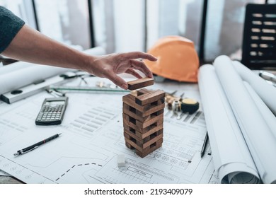 Engineering play. Blocks wood tower game (jenga) on blueprint factory, industry layout. Engineer and architect concept. - Shutterstock ID 2193409079