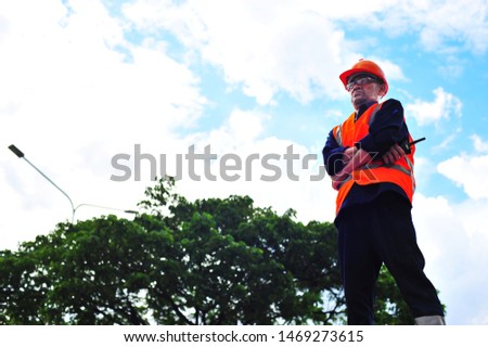 Engineering senior construction worker wearing safety helmet and safety vest.Engineer standing looking to the successful.