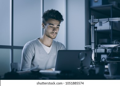 Engineering Student Working At Night In The Lab With A Laptop, 3D Printer In The Background