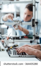 Engineering Students Working In The Lab, A Student Is Adjusting A 3D Printer's Components, The Other One On Foreground Is Using A Laptop