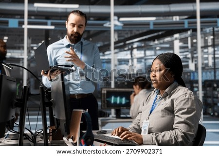 Engineering team doing brainstorming in data center, working together running scripts. Teamworking colleagues using programming language in server farm, finetuning network protocols