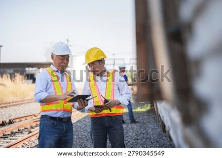 Engineering team inspecting old train carriage at industrial railyard, Professional rail logistics team conducting site inspection on abandoned train car